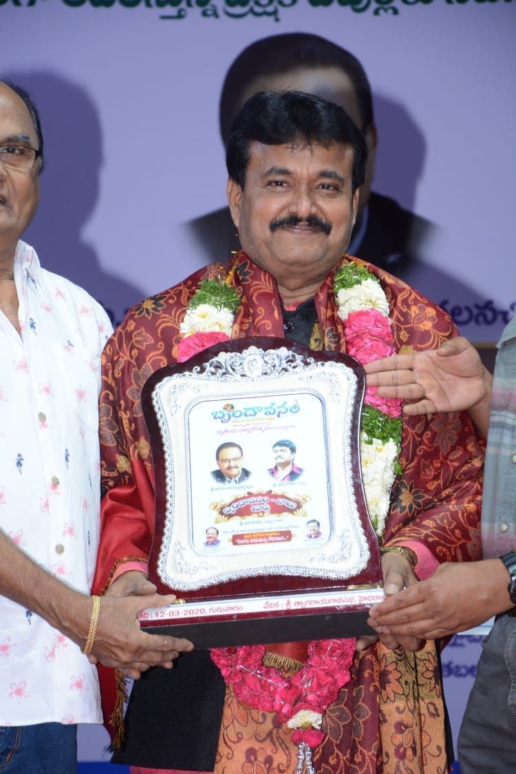 Ramu holding a commemorative plaque