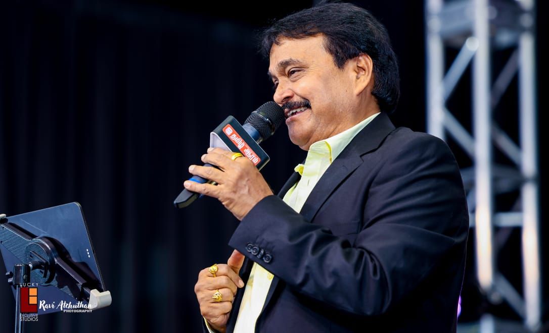 Ramu singing on an outdoor stage
